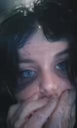 a woman with her hands on her face and dark hair covering her face