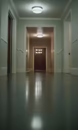 the view of a long hallway with a door to another room