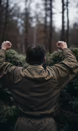 a man wearing a brown jacket in a forest