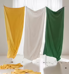 four yellow and green laundry drapes hanging near a window