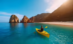 a man riding a kayak in the water near some rocks