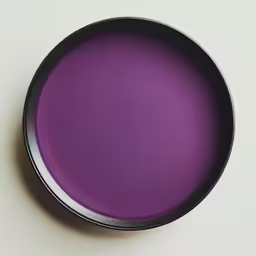 a purple powdered substance inside of a black bowl