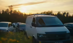 a white van parked in a lot with other cars behind it
