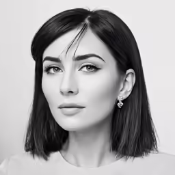 a woman with short hair wearing a white shirt and earrings