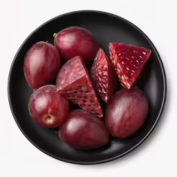 there is a black plate with pieces of fruit on it