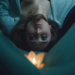 the girl is lying on the green bed