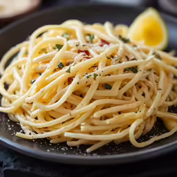 a plate with some noodles on it and a lemon wedge