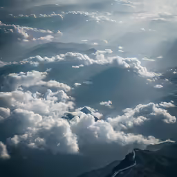 a photo taken from an airplane looking down at clouds and mountains