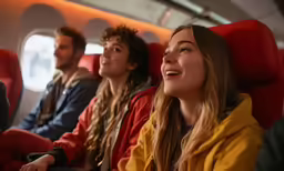 group of friends sit on the seat in airplane and look up