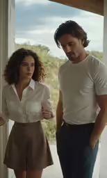 a man and woman stand together at the end of the hallway