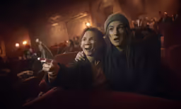 two people in an empty theatre, one pointing the camera