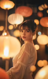 the woman is wearing a white shirt near a string of lights