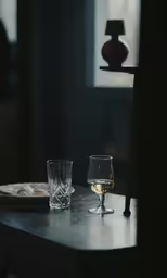 there are two glasses on the table with food in front of them