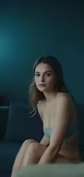 a beautiful young lady in a bikini sitting on top of a couch