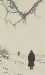 two people walking through the snow next to a tree