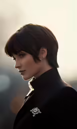 a woman with very short hair is in the sun