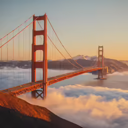 fog covers the ground below the golden gate bridge