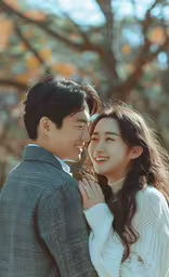 an asian couple smiling in front of a tree,a happy young couple embracing each other