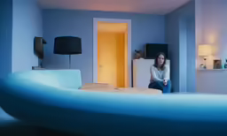 a woman sits on a bed with a blue mattress