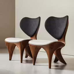 a pair of chairs sit in a white room
