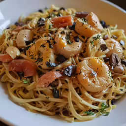 a dish is shown with shrimp, tomatoes, and black olives