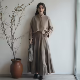 an asian woman is standing next to a plant