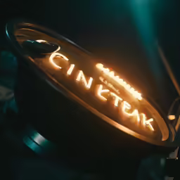 the cinkteak logo is lit up by the dim lighting