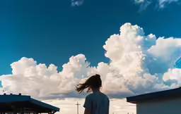 a woman looking out at the clouds above her
