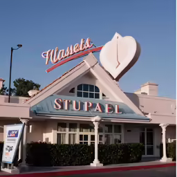a large white building that has a bunch of signs on the roof