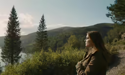 there is a woman sitting near a lake