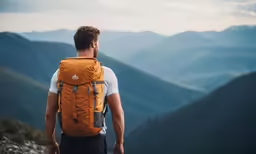 man looking at mountains and valleys in the distance