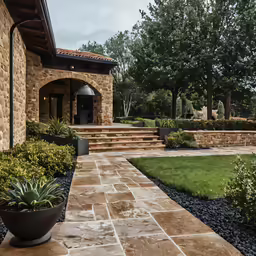 a garden area with stone steps leads up to a house