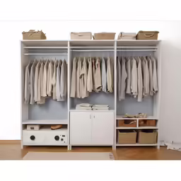 a walk - in closet has clothes and baskets on hangers