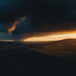an incredible sunset view over a valley with a cloud in the sky