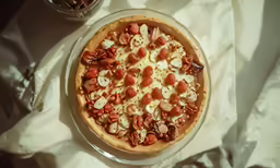 a pizza is shown on a table with a bowl and plates