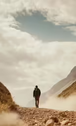 a man is walking on a dirt road