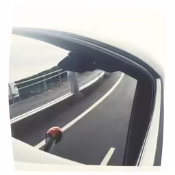 a vehicle is moving on a highway with the sunroof mirror partially visible