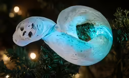 a fake white doughnut on display on a tree