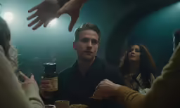 people sitting at a table drinking and some are talking