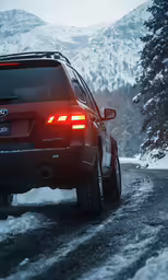 the lights of a car are turned on while driving through the snow