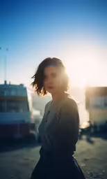 a young woman posing in front of boats at sunset