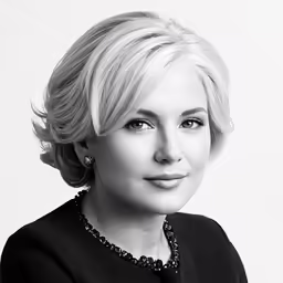 a woman with blond hair and a black jacket