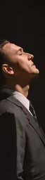 a man is dressed in black looking up at something
