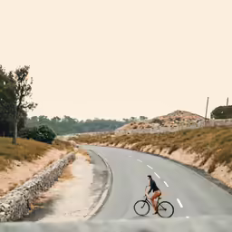 a man rides his bicycle on the empty highway