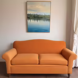 a large abstract painting hangs over an orange sofa