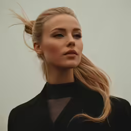 the woman is wearing a black suit and a hair piece