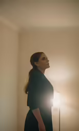the woman stands by the light turned on