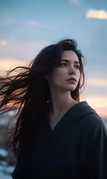 a girl with long hair stands against the sky
