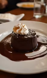 a plate topped with a chocolate desert covered in whipped cream