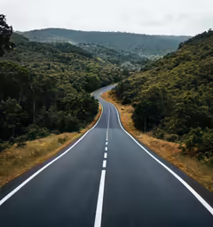 the straight road winds its way to the top of the hill